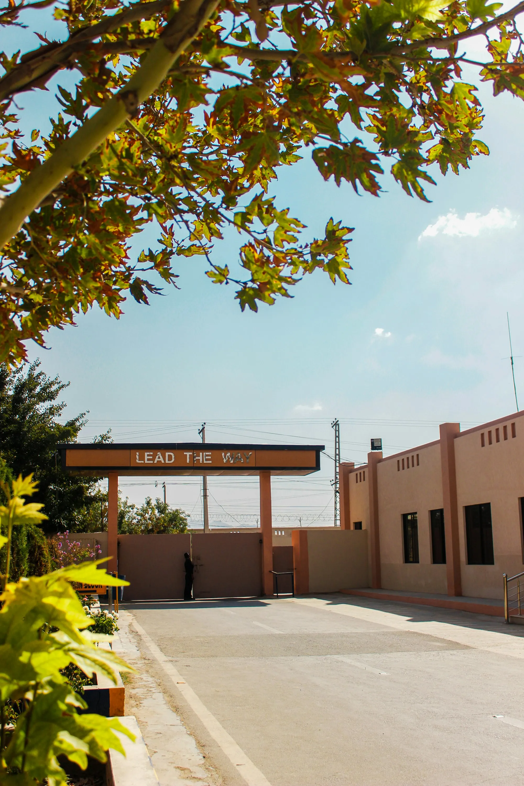 The gate and front wall of a school in Pakistan under a clear sky